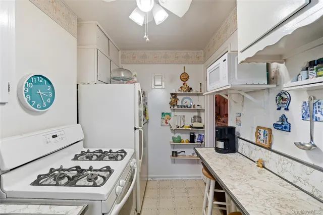 a kitchen with stainless steel appliances granite countertop a refrigerator a stove and a sink with wooden floor