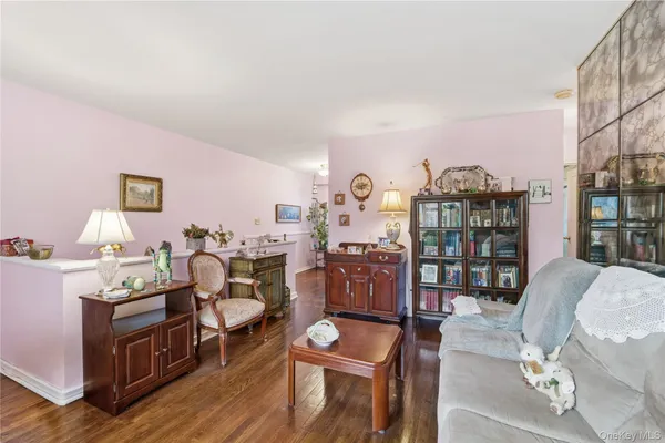 a living room with furniture a bookshelf and a wooden floor