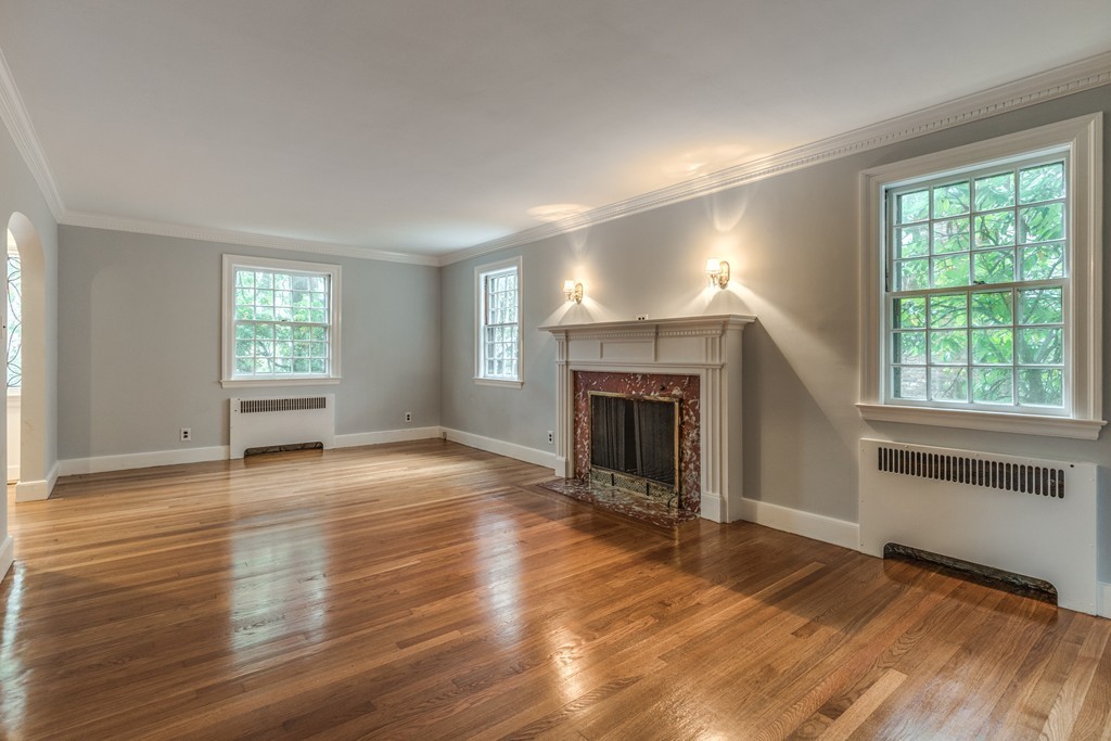 24 Gordon Road Milton, MA 02186 - Photo 11 of 30 an empty room with wooden floor fireplace and windows