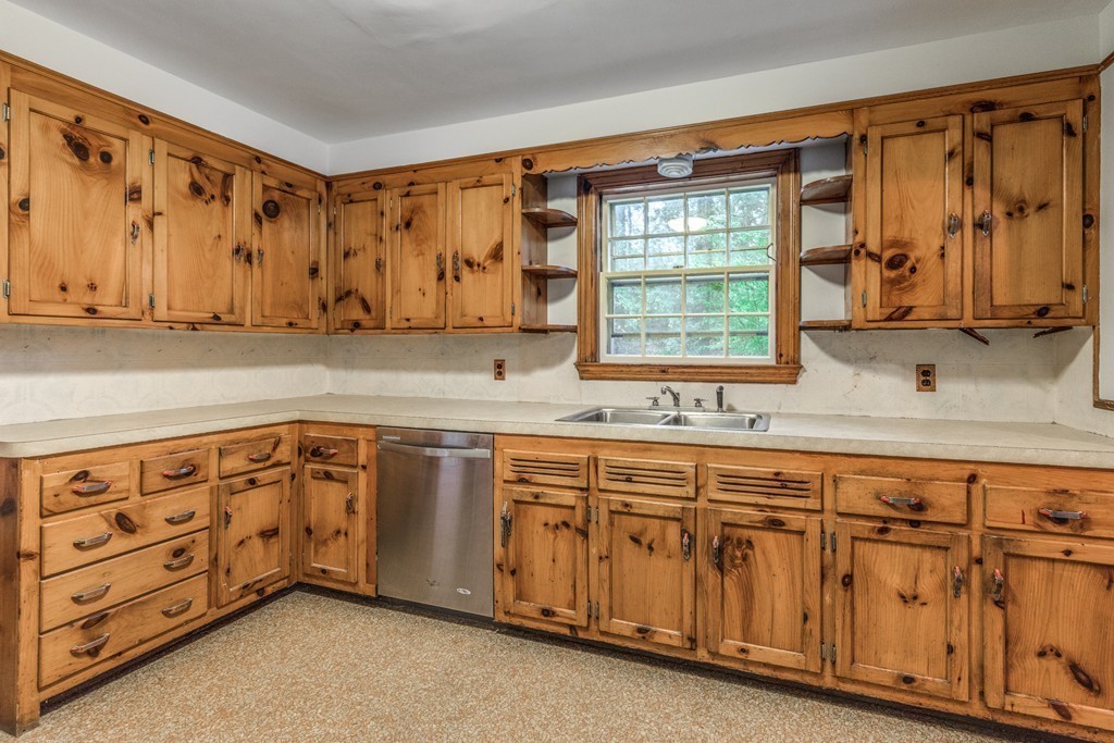 24 Gordon Road Milton, MA 02186 - Photo 17 of 30 a kitchen with granite countertop a sink cabinets and a window