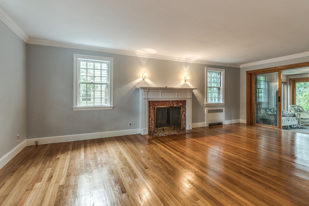24 Gordon Road Milton, MA 02186 - Photo 8 of 30 an empty room with wooden floor and fireplace