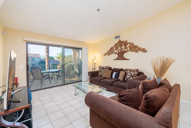 a living room with furniture and a floor to ceiling window