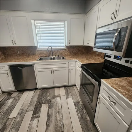 a kitchen with granite countertop a sink and a stove