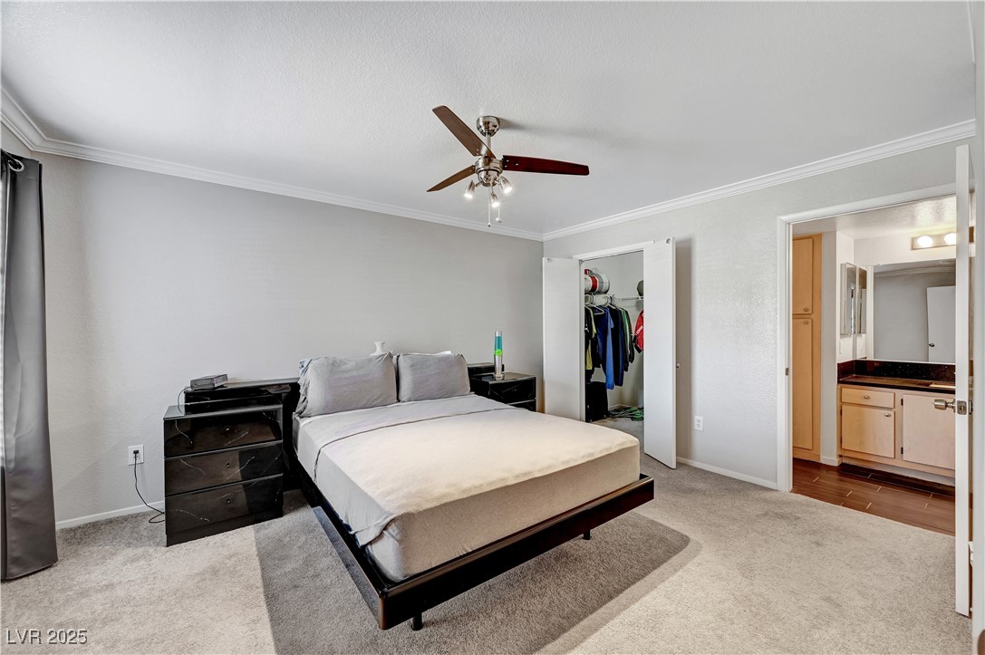8101 West Flamingo Road, Unit 1163 Las Vegas, NV 89147 - Photo 24 of 45 Bedroom with crown molding, light colored carpet, a ceiling fan, and a spacious closet