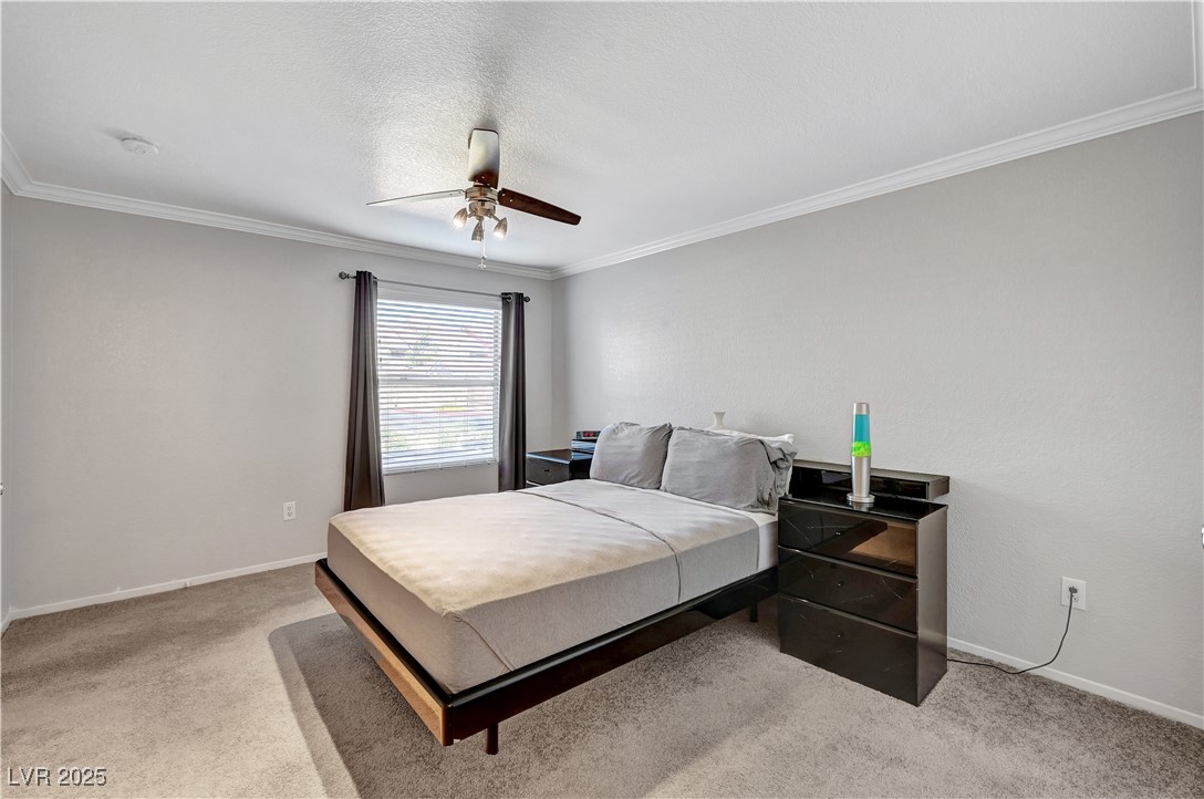 8101 West Flamingo Road, Unit 1163 Las Vegas, NV 89147 - Photo 25 of 45 Bedroom with ornamental molding, a ceiling fan, light carpet, and a textured ceiling
