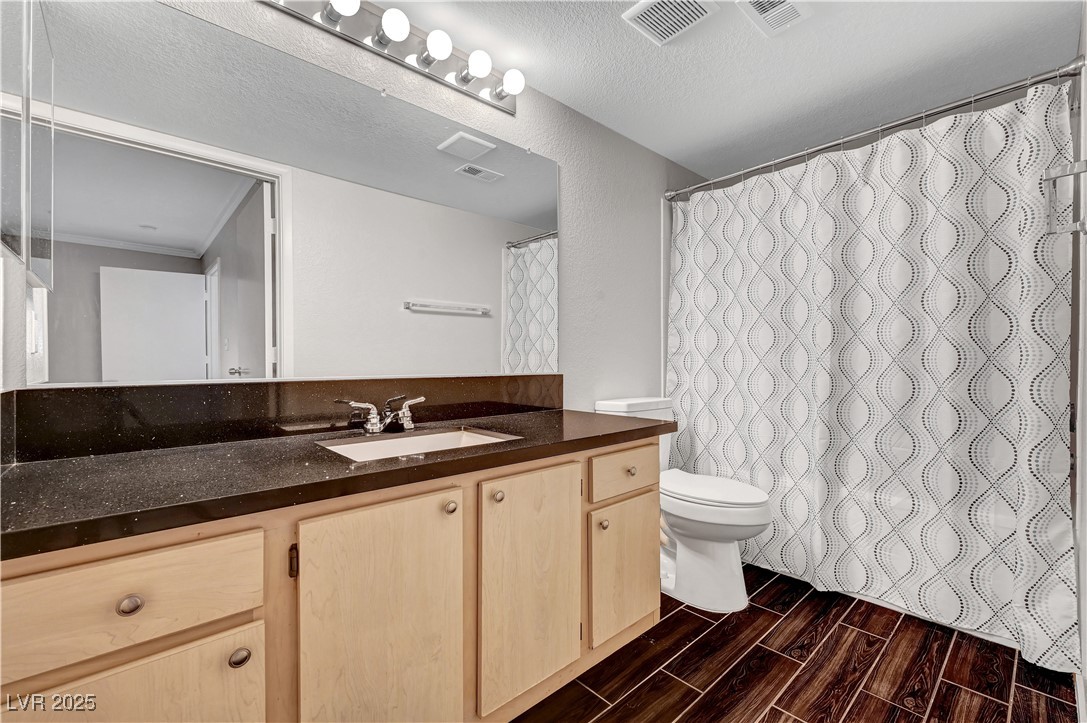 8101 West Flamingo Road, Unit 1163 Las Vegas, NV 89147 - Photo 27 of 45 Full bathroom featuring vanity, wood tiled floors, a textured ceiling, and a shower with shower curtain