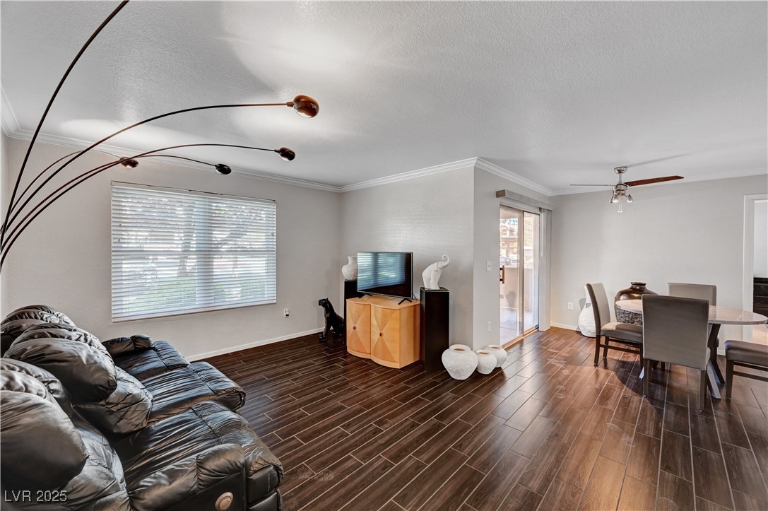 8101 West Flamingo Road, Unit 1163 Las Vegas, NV 89147 - Photo 3 of 45 Living area featuring ornamental molding, wood tiled floors, ceiling fan, and a textured ceiling