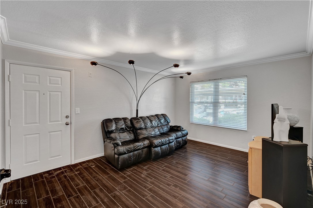 8101 West Flamingo Road, Unit 1163 Las Vegas, NV 89147 - Photo 4 of 45 Living area featuring ornamental molding, a textured ceiling, and wood finish floors