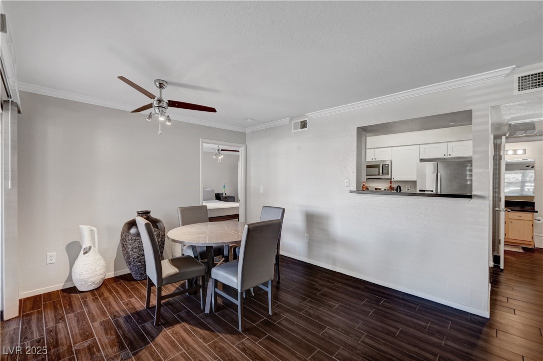 8101 West Flamingo Road, Unit 1163 Las Vegas, NV 89147 - Photo 10 of 45 Dining room with wood tiled floors, ornamental molding, and a ceiling fan