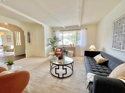 a living room with furniture potted plant and large windows