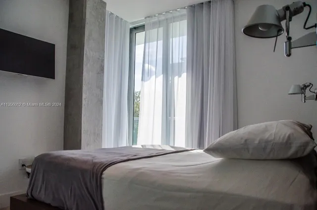 a bedroom with a bed and a window