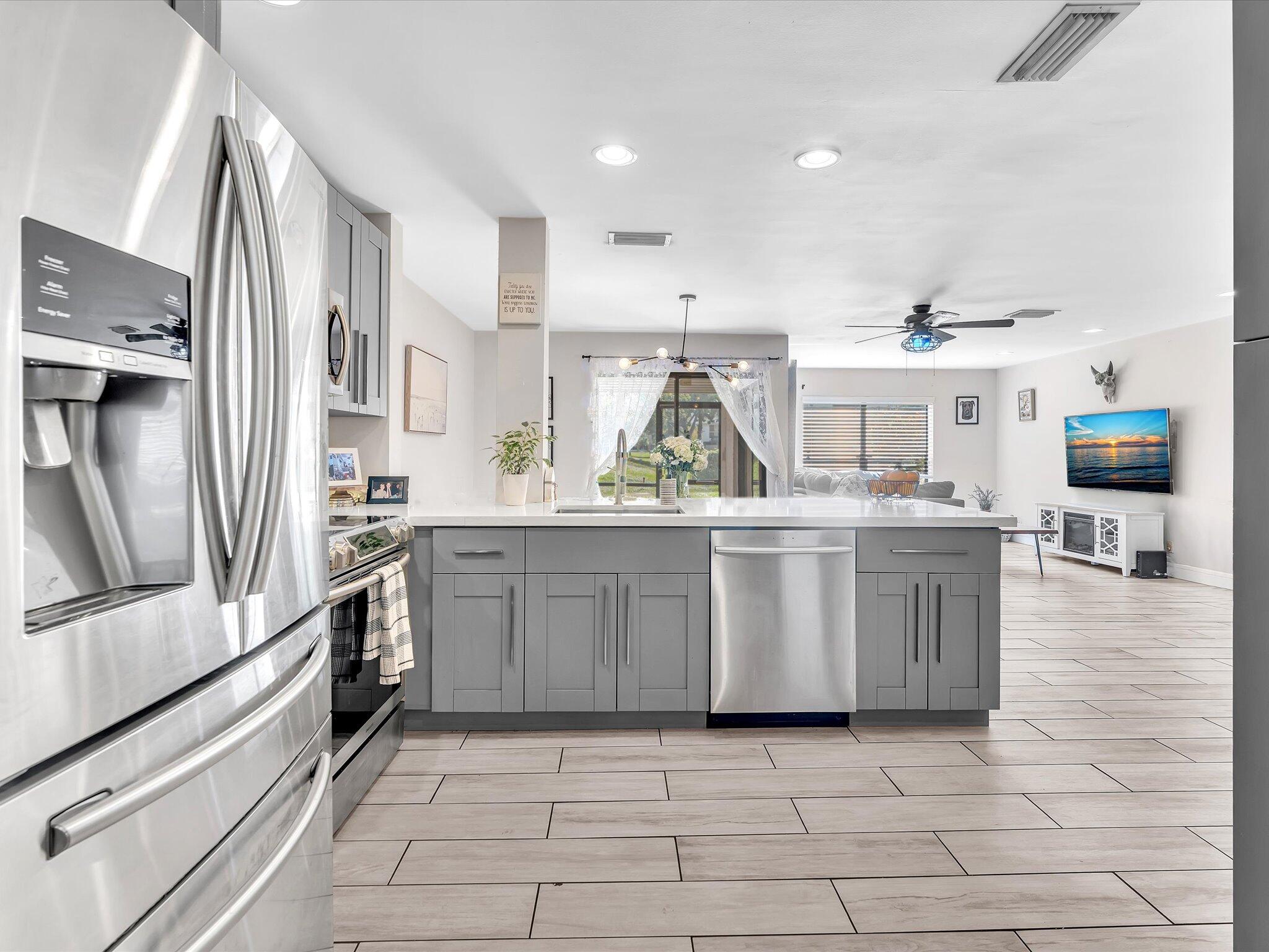 4441 Northwest 22nd Road, Unit 414 Coconut Creek, FL 33066 - Photo 11 of 60 a kitchen with stainless steel appliances a stove a sink and a refrigerator