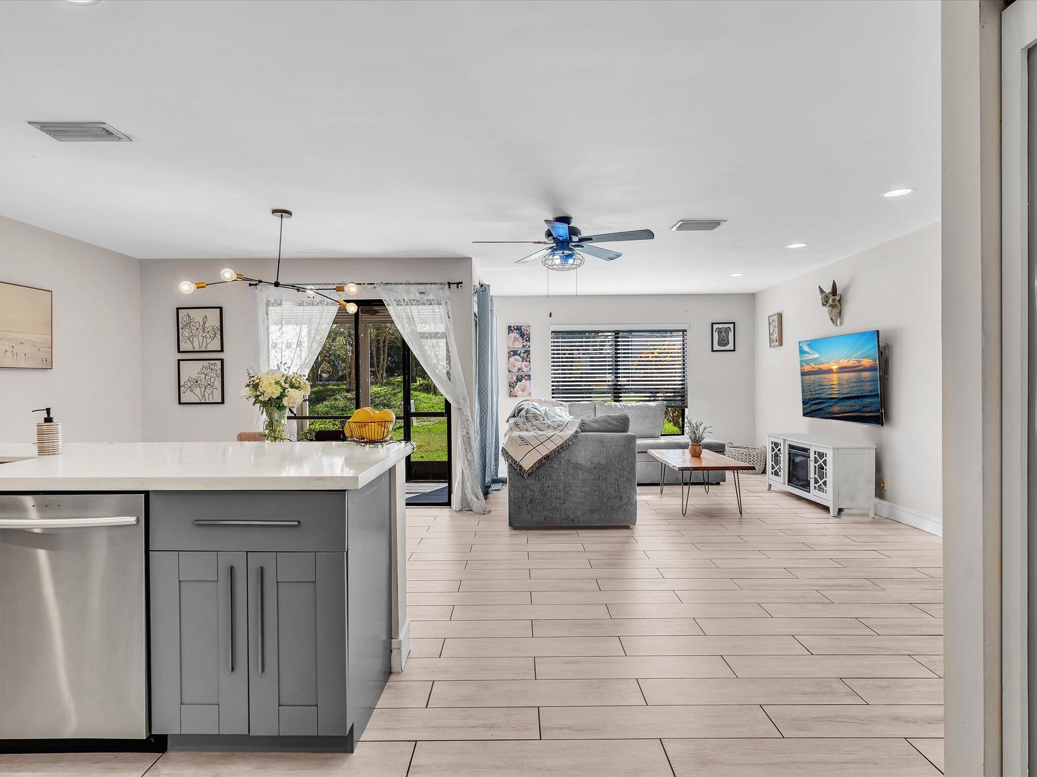 4441 Northwest 22nd Road, Unit 414 Coconut Creek, FL 33066 - Photo 14 of 60 a living room with furniture a flat screen tv and kitchen view