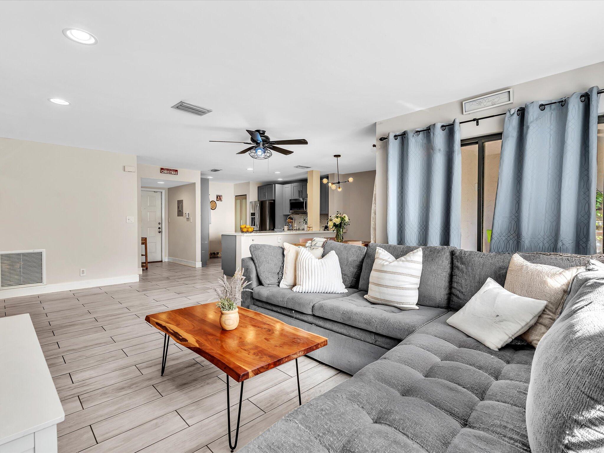 4441 Northwest 22nd Road, Unit 414 Coconut Creek, FL 33066 - Photo 22 of 60 a living room with furniture a rug and a chandelier