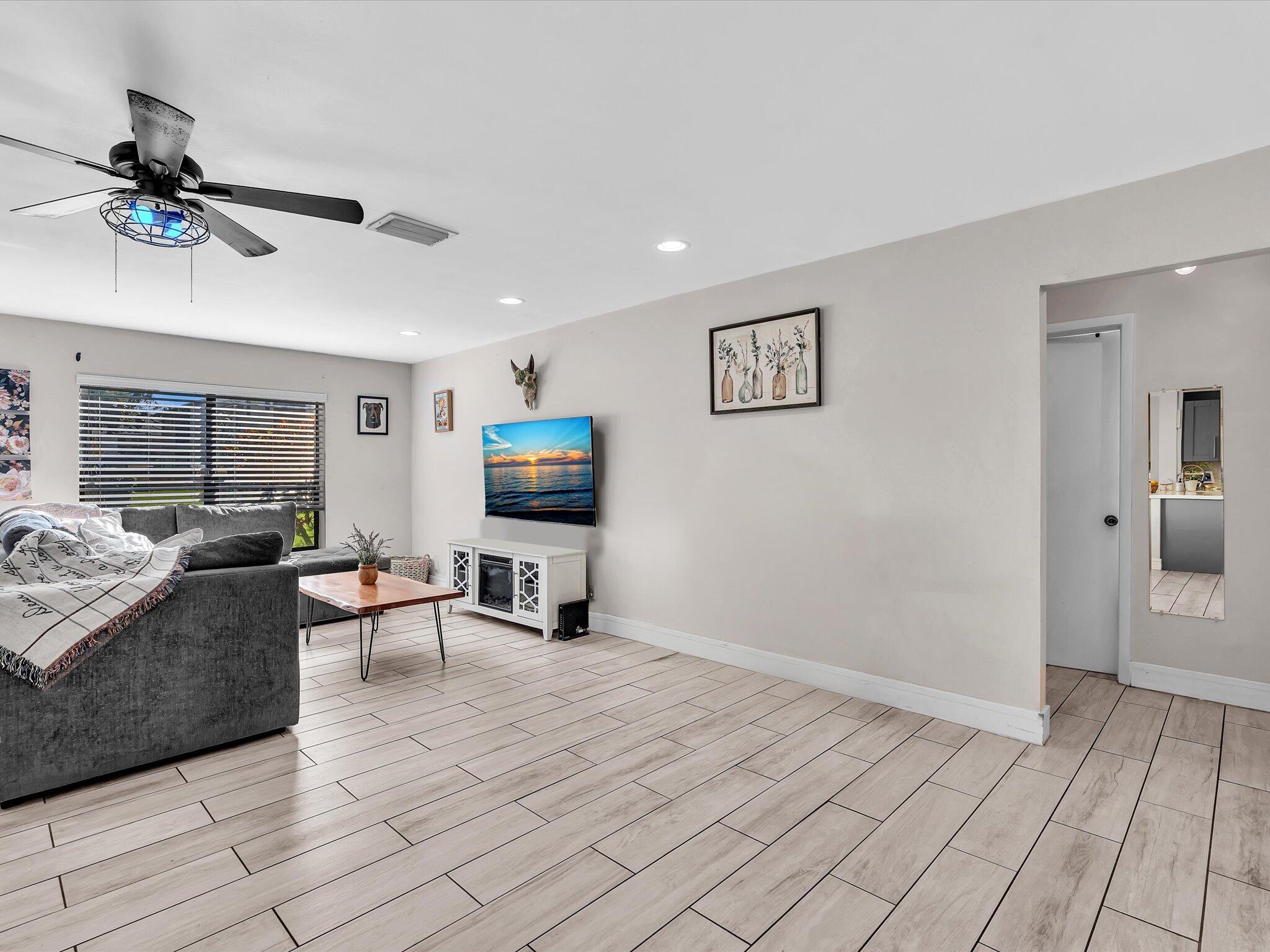 4441 Northwest 22nd Road, Unit 414 Coconut Creek, FL 33066 - Photo 23 of 60 a view of a livingroom with furniture and a flat screen tv