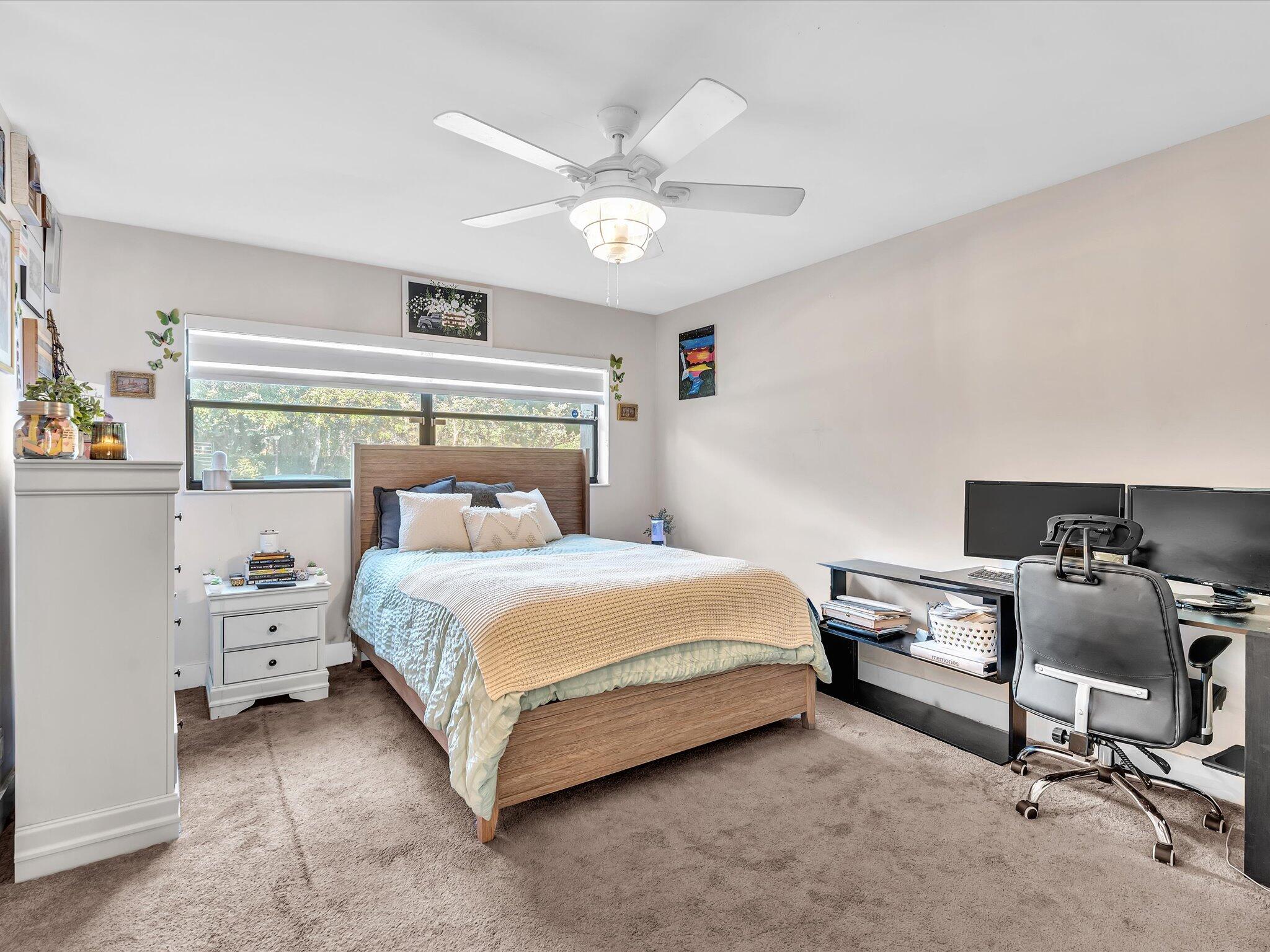 4441 Northwest 22nd Road, Unit 414 Coconut Creek, FL 33066 - Photo 27 of 60 a bedroom with a bed and a chandelier