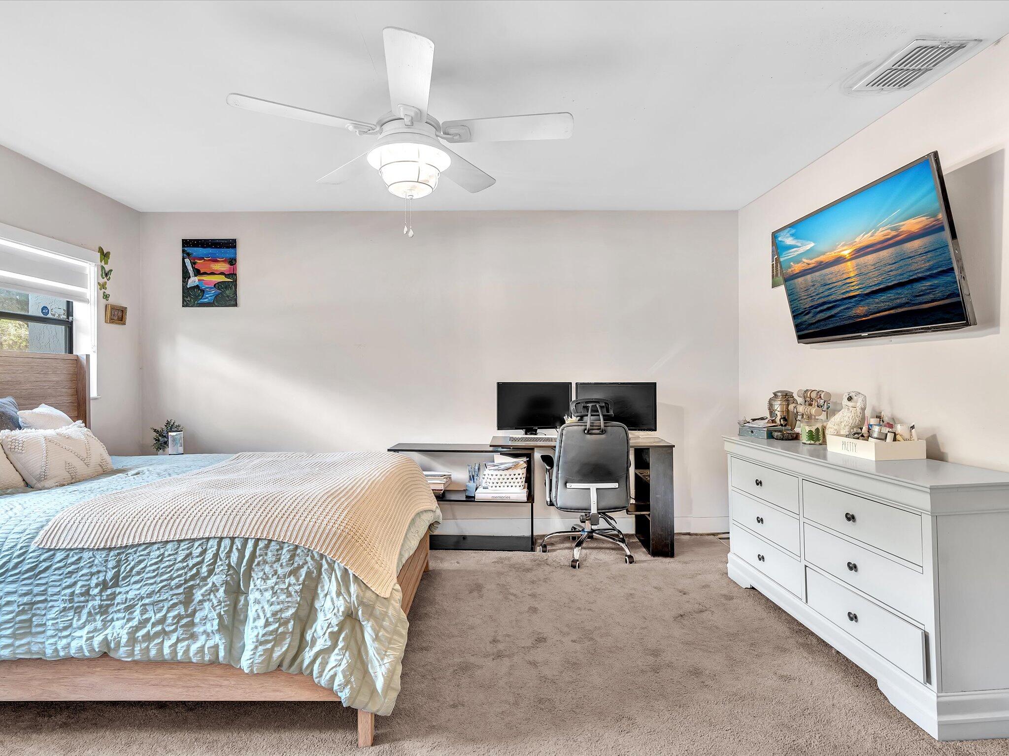 4441 Northwest 22nd Road, Unit 414 Coconut Creek, FL 33066 - Photo 28 of 60 a bedroom with a bed and a flat screen tv