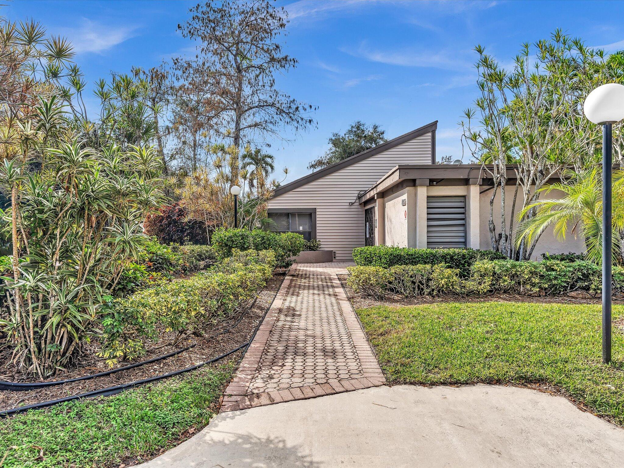 4441 Northwest 22nd Road, Unit 414 Coconut Creek, FL 33066 - Photo 43 of 60 front view of a house with a yard