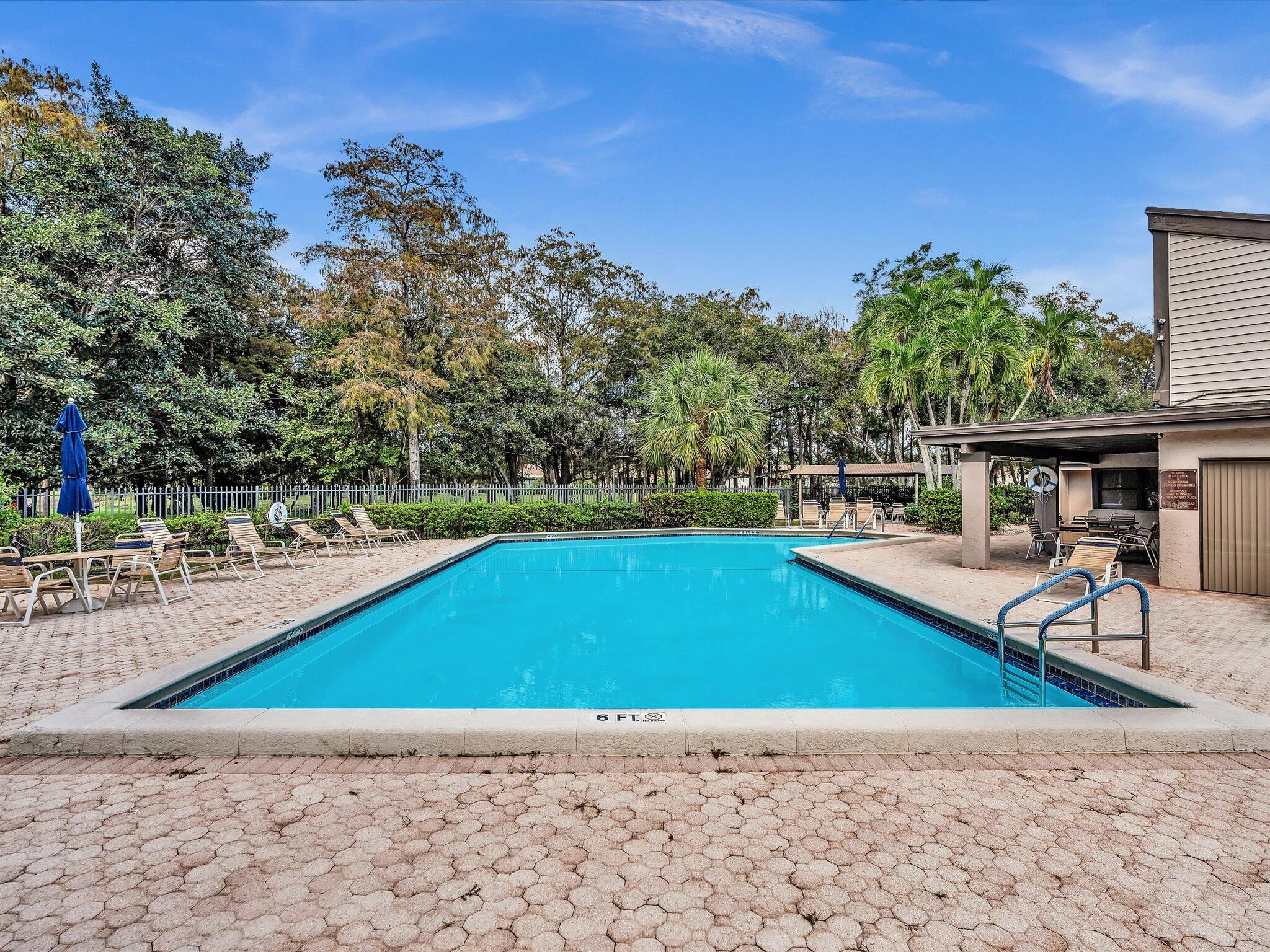 4441 Northwest 22nd Road, Unit 414 Coconut Creek, FL 33066 - Photo 44 of 60 a view of a swimming pool with a patio
