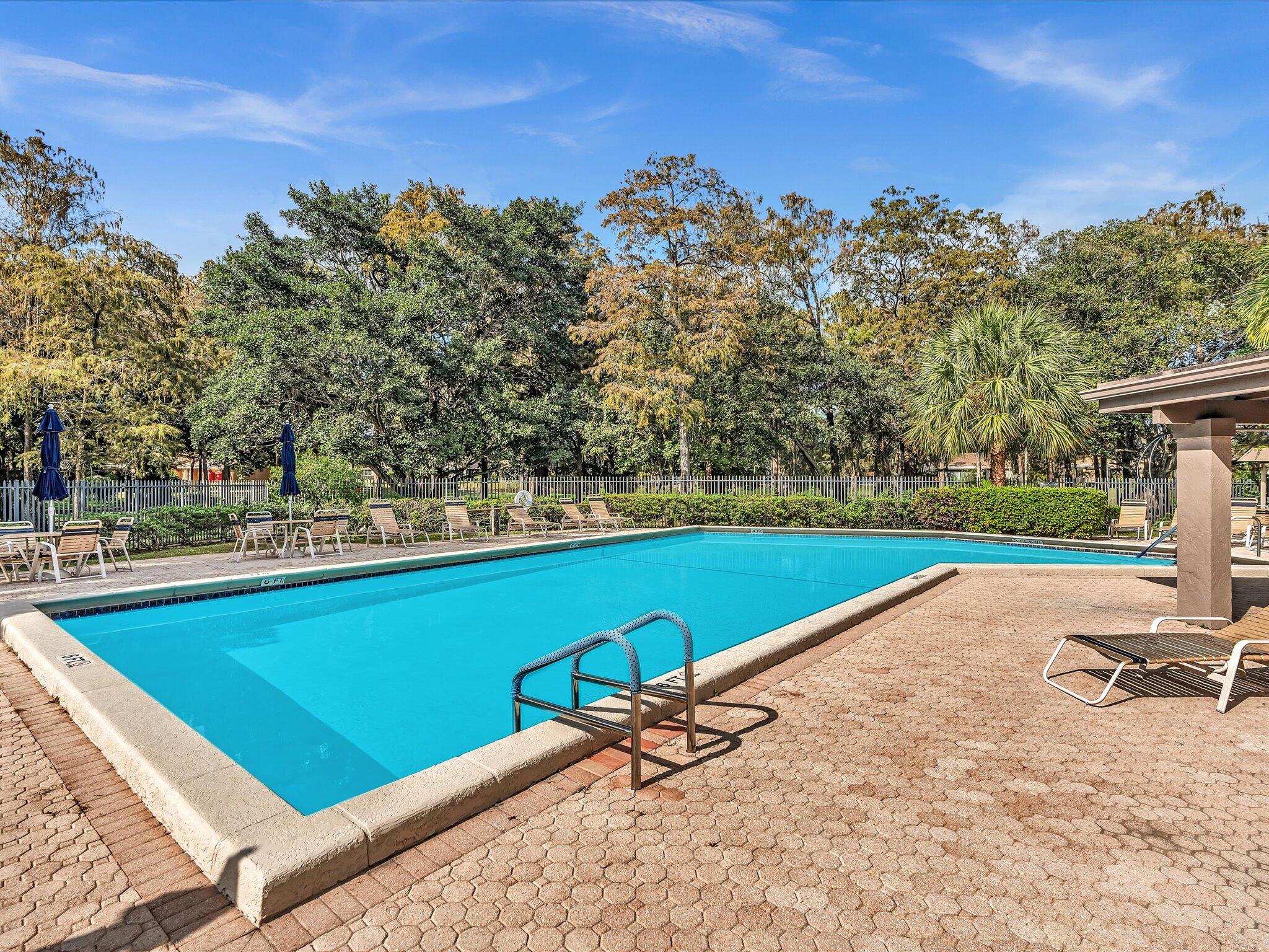 4441 Northwest 22nd Road, Unit 414 Coconut Creek, FL 33066 - Photo 45 of 60 a view of a swimming pool with a lounge chair