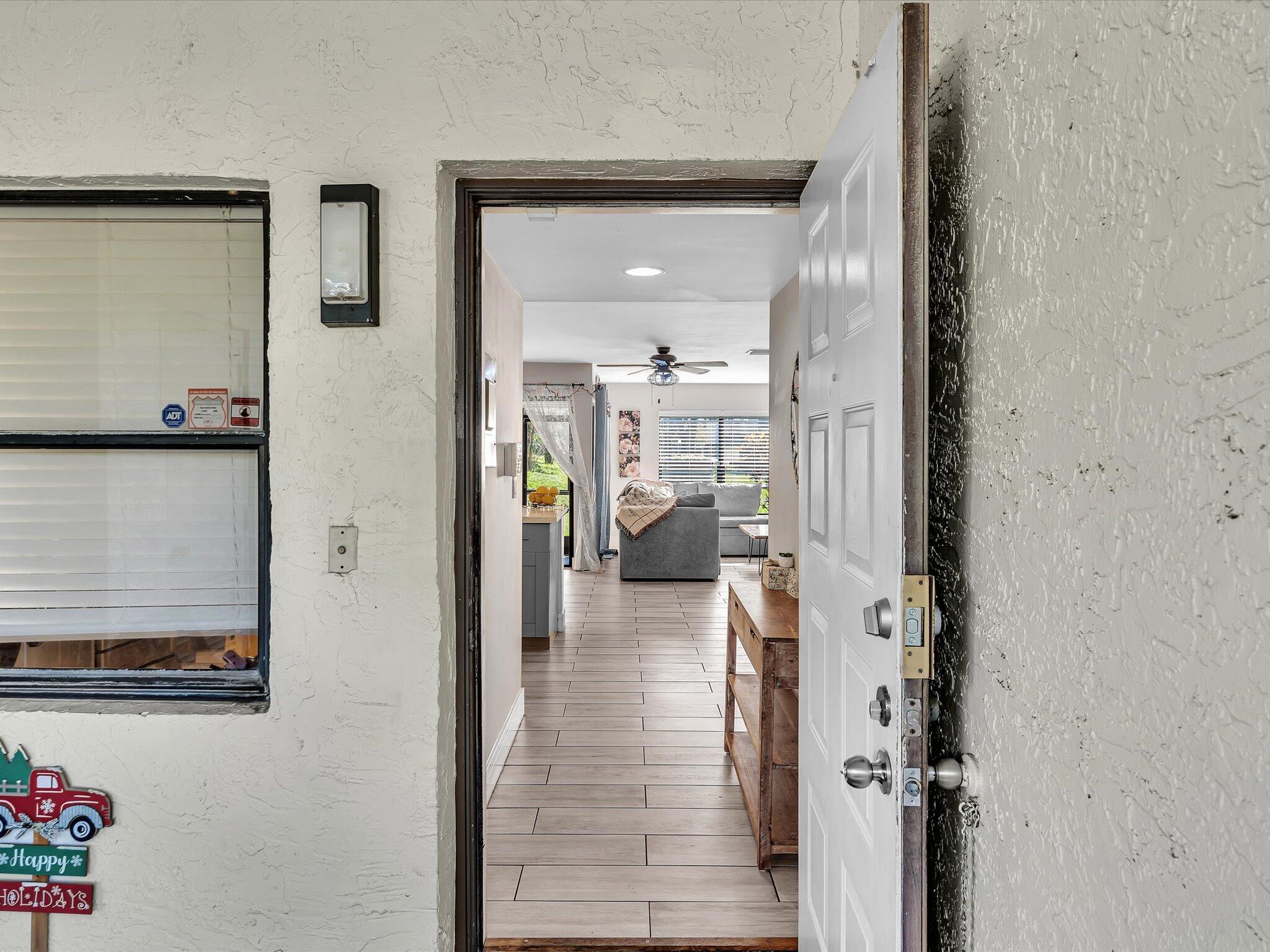 4441 Northwest 22nd Road, Unit 414 Coconut Creek, FL 33066 - Photo 5 of 60 a view of a hallway with wooden floor windows and a livingroom