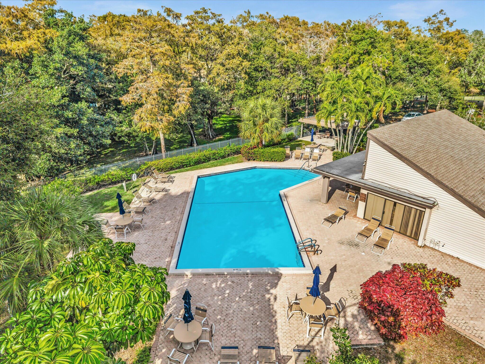 4441 Northwest 22nd Road, Unit 414 Coconut Creek, FL 33066 - Photo 53 of 60 a view of yard with swimming pool and trees in the background