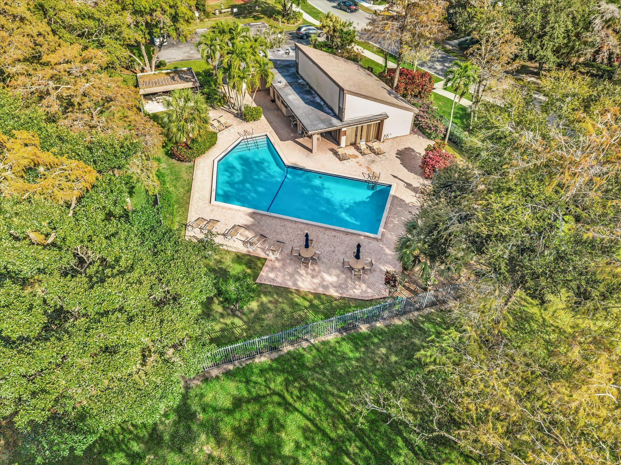 4441 Northwest 22nd Road, Unit 414 Coconut Creek, FL 33066 - Photo 54 of 60 an aerial view of a house with a yard and tennis court