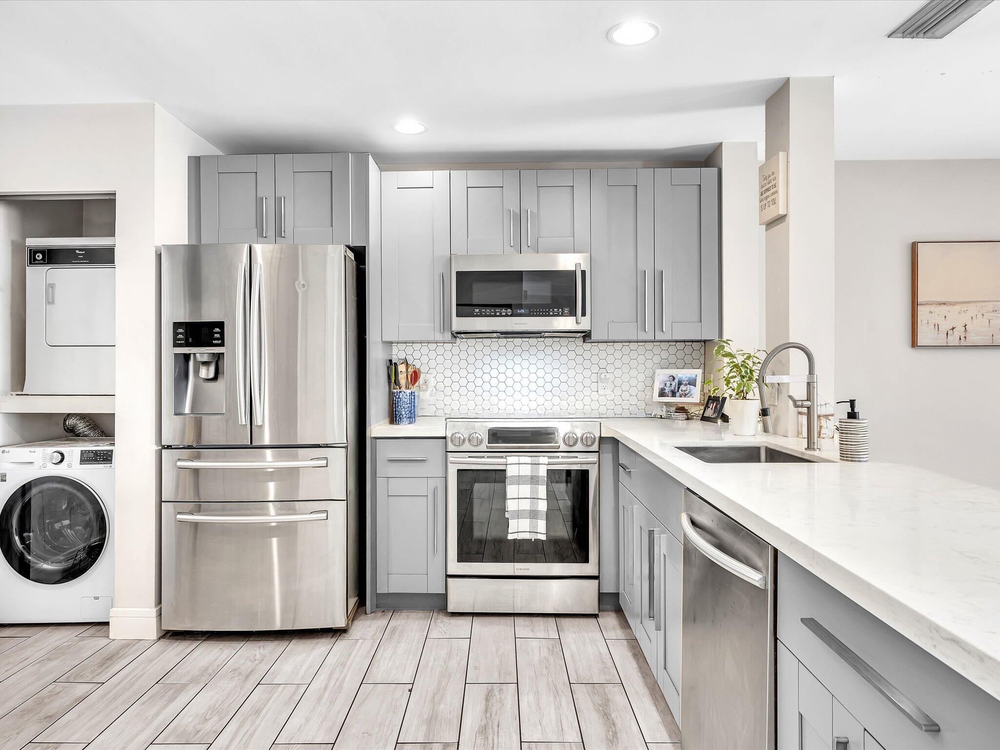 4441 Northwest 22nd Road, Unit 414 Coconut Creek, FL 33066 - Photo 8 of 60 a kitchen with a refrigerator sink and wooden floor