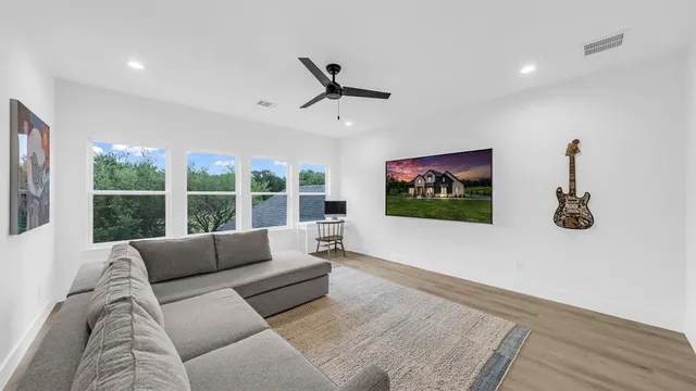 a living room with furniture floor to ceiling window and a flat screen tv
