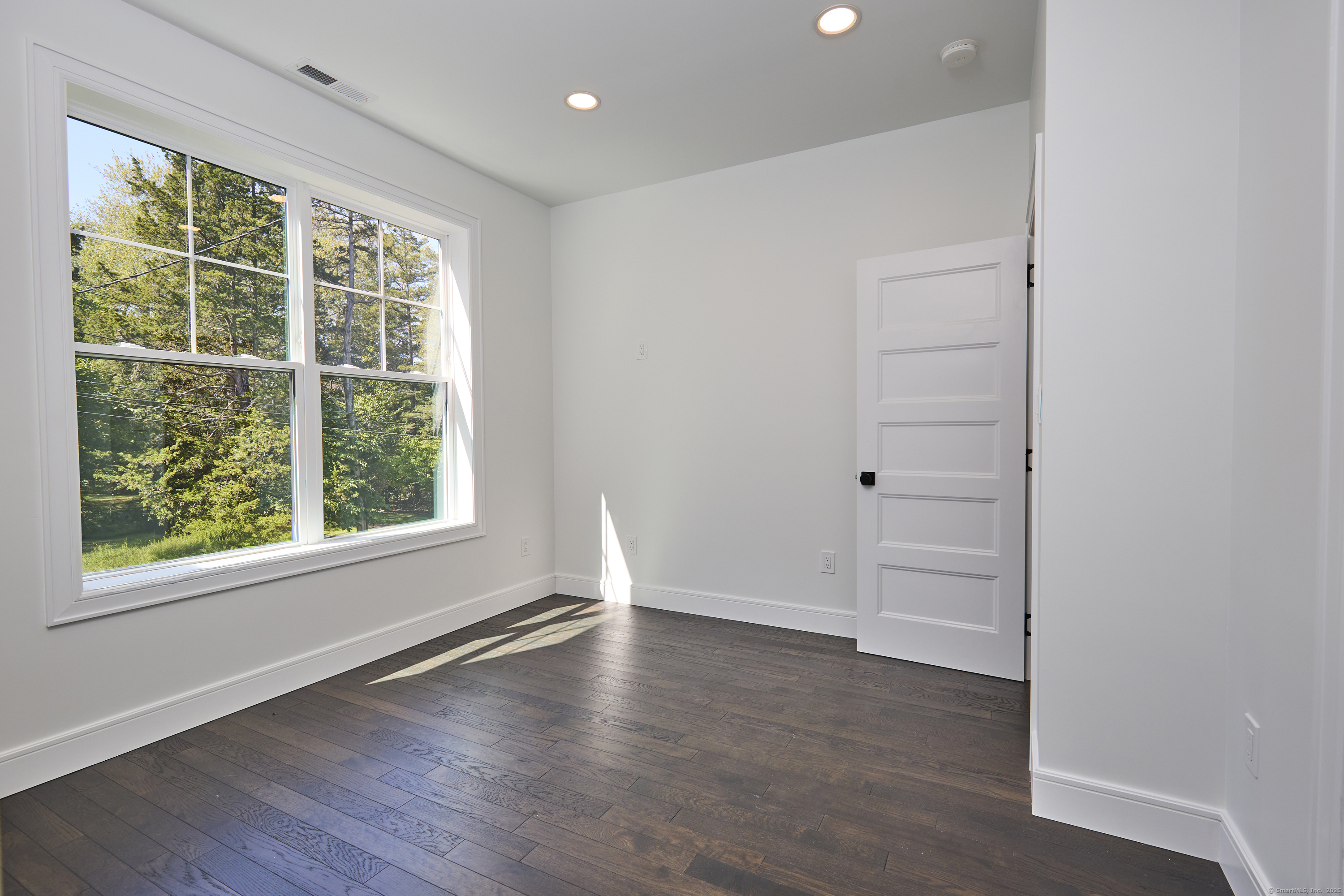 1207 Stillson Road Fairfield, CT 06824 - Photo 25 of 39 an empty room with wooden floor and windows