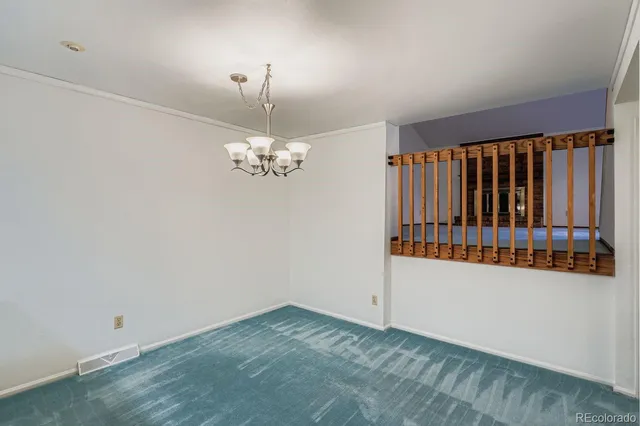 an empty room with chandelier fan and windows