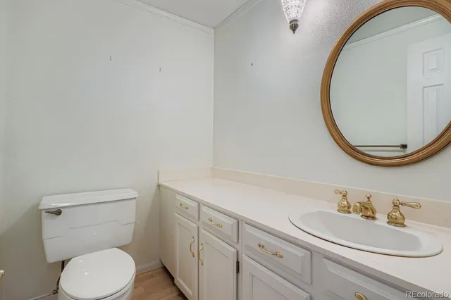 a bathroom with a toilet sink vanity and mirror