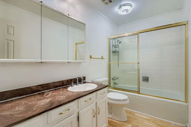 a bathroom with a shower sink vanity mirror and toilet