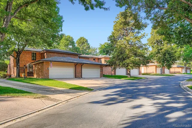 a front view of a house with a yard and trees
