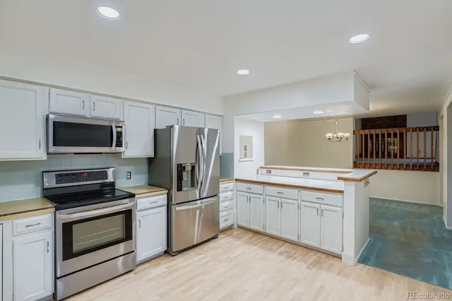 a kitchen with a sink stainless steel appliances and white cabinets