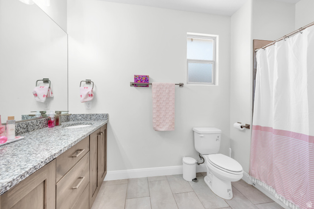 6105 Bunda Way St. George, UT 84790 - Photo 26 of 49 Bathroom featuring a single vanity with stone countertop, undermount sink, and wood-finish cabinetry