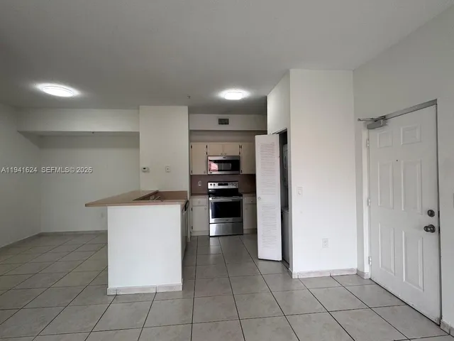 a kitchen with a refrigerator and a stove top oven