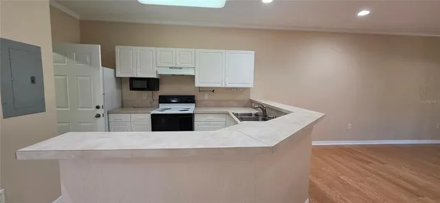 a kitchen with white cabinets and appliances