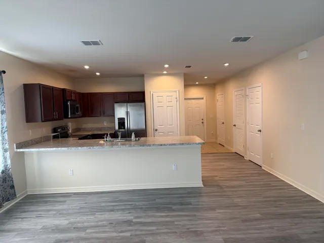 a view of kitchen with kitchen island stainless steel appliances refrigerator stove microwave and cabinets