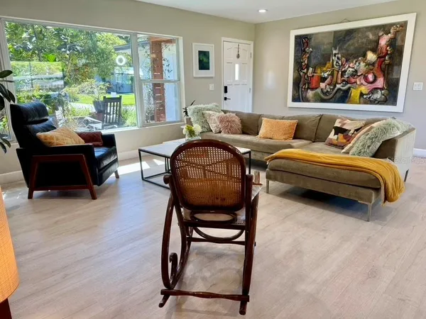 a living room with stainless steel appliances kitchen island granite countertop furniture and a large window