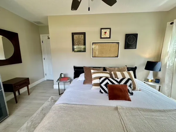 a view of a chair and table under an umbrella in backyard