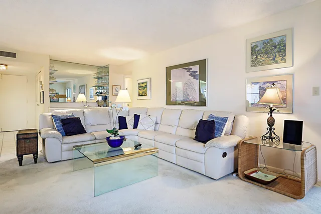 a living room with furniture white walls and a lamp