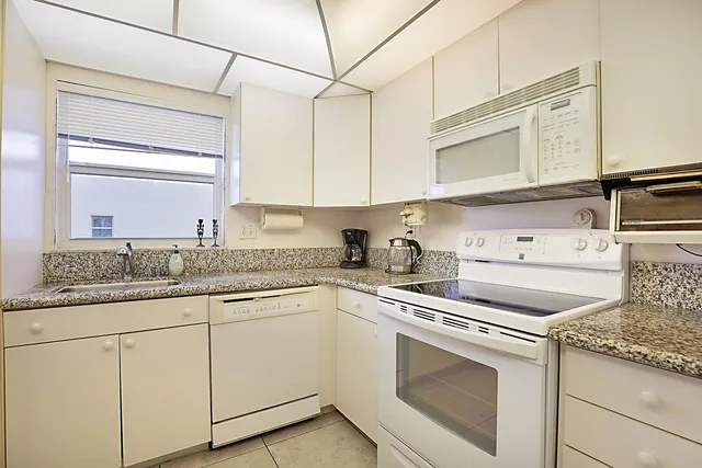 a kitchen with granite countertop cabinets sink and stainless steel appliances