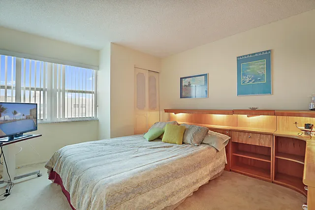 a bedroom with a bed and a lamp on dresser