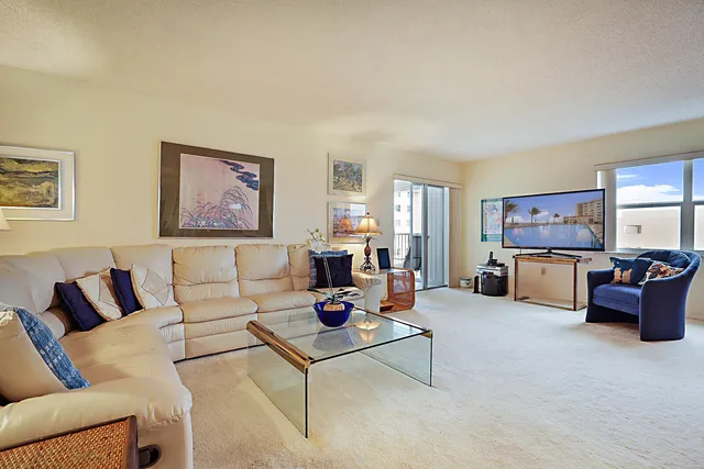 a living room with furniture large window and wall painting