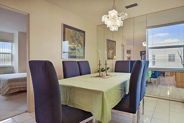 a view of a dining room with furniture a chandelier and wooden floor