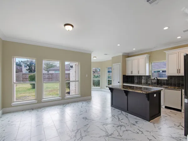 a view of a kitchen with stainless steel appliances granite countertop a refrigerator and a stove top oven