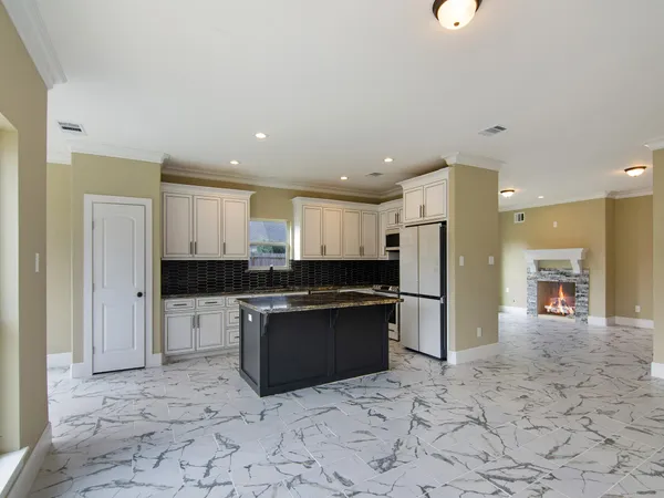 a kitchen with stainless steel appliances granite countertop a refrigerator and a sink