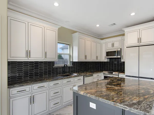a kitchen with stainless steel appliances granite countertop a sink a stove and cabinets