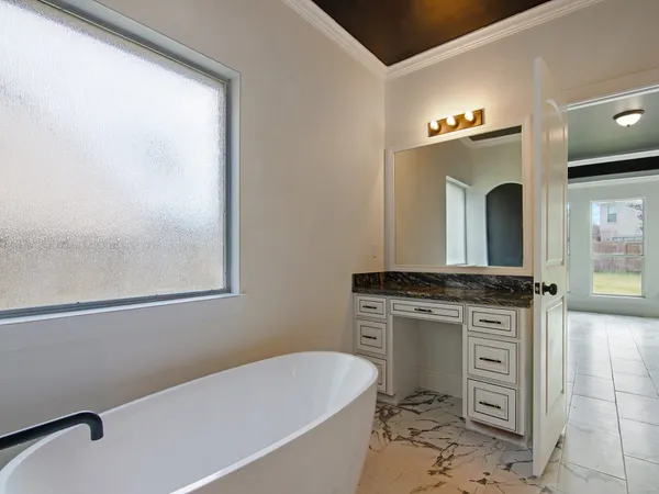 a bathroom with a granite countertop sink mirror vanity and bathtub
